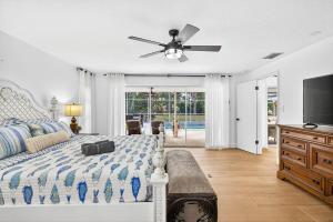 a bedroom with a bed and a ceiling fan at Spacious Clearwater House 4BR 3BA Private Pool in Clearwater +67 photos