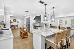 a kitchen with a large island with bar chairs at Spacious Clearwater House 4BR 3BA Private Pool in Clearwater