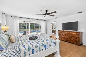 a bedroom with a bed and a flat screen tv at Spacious Clearwater House 4BR 3BA Private Pool in Clearwater