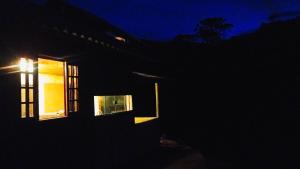 a house with a window in the dark at Chalé dos ventos in Itamonte +3 photos
