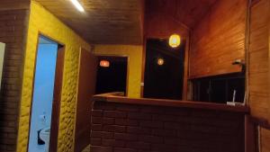 a room with a mirror and a brick wall at Chalé dos ventos in Itamonte