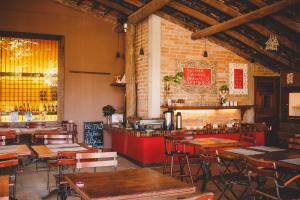 a restaurant with wooden tables and chairs and a bar at Alua Camburi in Camburi
