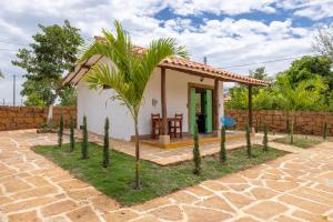 a small house with a palm tree in front of it at Cabañas Campestres El Vaticano in Barichara +1 photo