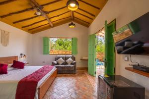 a bedroom with a bed and a couch in a room at Cabañas Campestres El Vaticano in Barichara