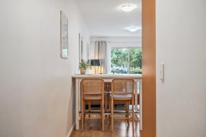 a kitchen with a bar with chairs around it at Carrington Views - 3 Bedrooms - CBD - Parking in Adelaide