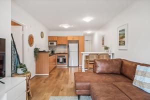 a living room with a couch and a kitchen at Carrington Views - 3 Bedrooms - CBD - Parking in Adelaide