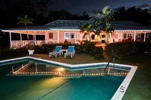 a house with a swimming pool in front of a house at The Rocks Villa in Tower Isle