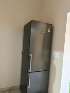 a stainless steel refrigerator in a corner of a room at Aura by bala in Dehradun