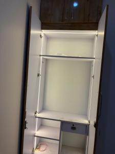 a white refrigerator with its door open in a room at Aura by bala in Dehradun +2 photos