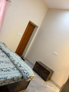 a bedroom with a bed and a wooden door at Aura by bala in Dehradun