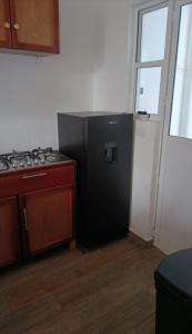 a kitchen with a black refrigerator and a stove at Coastal Charm in Ixtapa