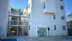 a white building with a door and a balcony at Coastal Charm in Ixtapa