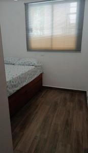 a bedroom with a bed and a wooden floor at Coastal Charm in Ixtapa