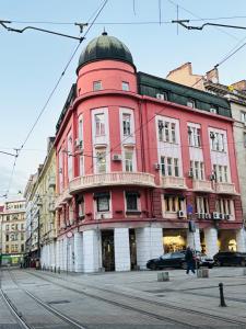 a red building with a dome on top of it at Experience at Malinova dolina in Sofia