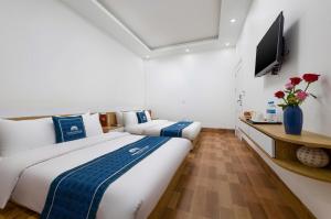 a hotel room with two beds and a television at LAN HA PEARL HOTEl in Phù Long