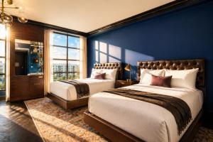 a bedroom with two beds and a blue wall at Whisky Hotel in Los Angeles