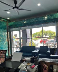 a living room with blue couches and a window at Hotel Blue Orchid in Bayan Lepas