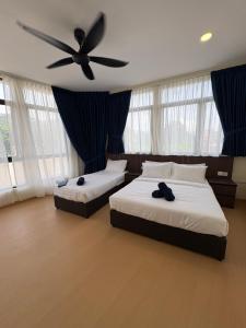 a bedroom with two beds and a ceiling fan at Tdoze Hotel At Piccadilly Ipoh in Ipoh +32 photos