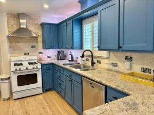 a blue kitchen with a sink and a stove at Casa Blanca in Irving