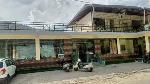 two scooters parked in front of a building at RK Residency Hotel & Resturant in Ukhimath