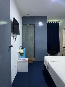 a room with a bed and a door with a table at Hotel Blue Orchid in Bayan Lepas