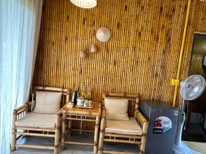 a room with two chairs and a table and a fan at Om Tara Retreat in Yên Bái
