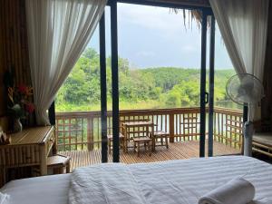 a bedroom with a bed and a balcony with a view at Om Tara Retreat in Yên Bái