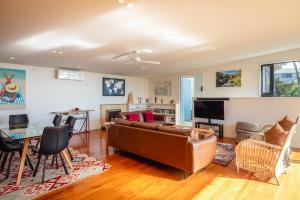 a living room with a couch and a table at Hekerua Heights with Hot Tub and Seaviews in Oneroa