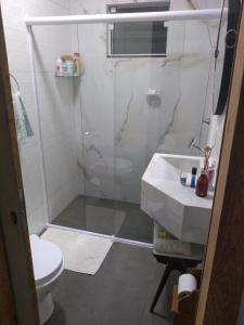 a bathroom with a shower and a sink and a toilet at Casa Goiaba in Piçarras