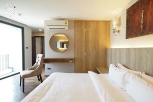 a bedroom with a large white bed and a chair at The 28th Hotel in Kanchanaburi City +63 photos