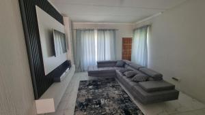 a living room with a couch and a tv at 124 On Comet Oaks in Boksburg