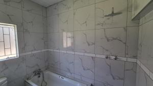 a bathroom with a shower and a tub and a sink at 124 On Comet Oaks in Boksburg