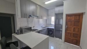 a kitchen with a sink and a stove and a door at 124 On Comet Oaks in Boksburg