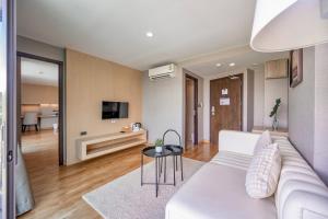 a living room with a white couch and a table at The 28th Hotel in Kanchanaburi City