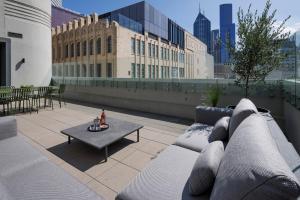 a rooftop patio with a couch and a table at The Howey in Melbourne