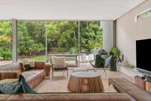a living room with couches and a large window at Dune Ten in Fingal Head