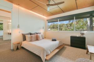 a bedroom with a bed and a large window at Dune Ten in Fingal Head