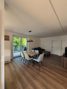 a living room with a dining room table and chairs at Pollross Apartments in Reichenau +5 photos