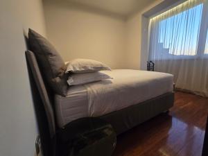 a bedroom with a bed with pillows and a window at Rosewood Podgorica in Podgorica
