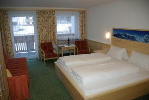 1 Schlafzimmer mit 2 Betten, einem Tisch und Stühlen in der Unterkunft Alpenhof Pension-Garni in Nauders