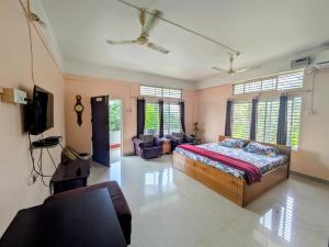 a bedroom with a bed and a living room at Gogona Homestay in Guwahati