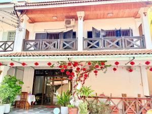 a house with red flowers in front of it at Elephant Hotel Luang Parabang in Luang Prabang