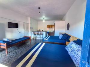 a living room with two beds and a kitchen at Pousada Mar de Itacaré in Itacaré