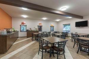 a restaurant with tables and chairs and a flat screen tv at Quality Inn Airport in Moncton