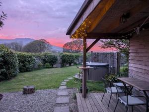 a patio with a table and chairs and a grill at Cosy Eco Cabin in Newport