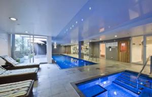 a large swimming pool in a large house at Lux 2BR Apt on Hindmarsh SQ-Pool-Gym-Parking in Adelaide
