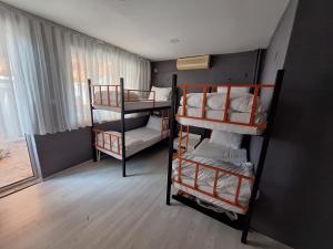 a room with three bunk beds and a window at Dilmac Hotel in Gelibolu