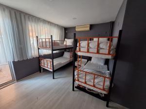 a room with three bunk beds and a window at Dilmac Hotel in Gelibolu