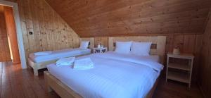 a bedroom with two beds in a wooden cabin at Ramlejowe Wzgórze - Sauna-Balia in Ostrzyce