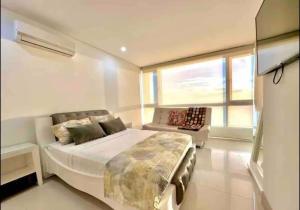 a bedroom with a large bed and a couch at Large 3BR Apt with beautiful ocean views in Cartagena de Indias +27 photos